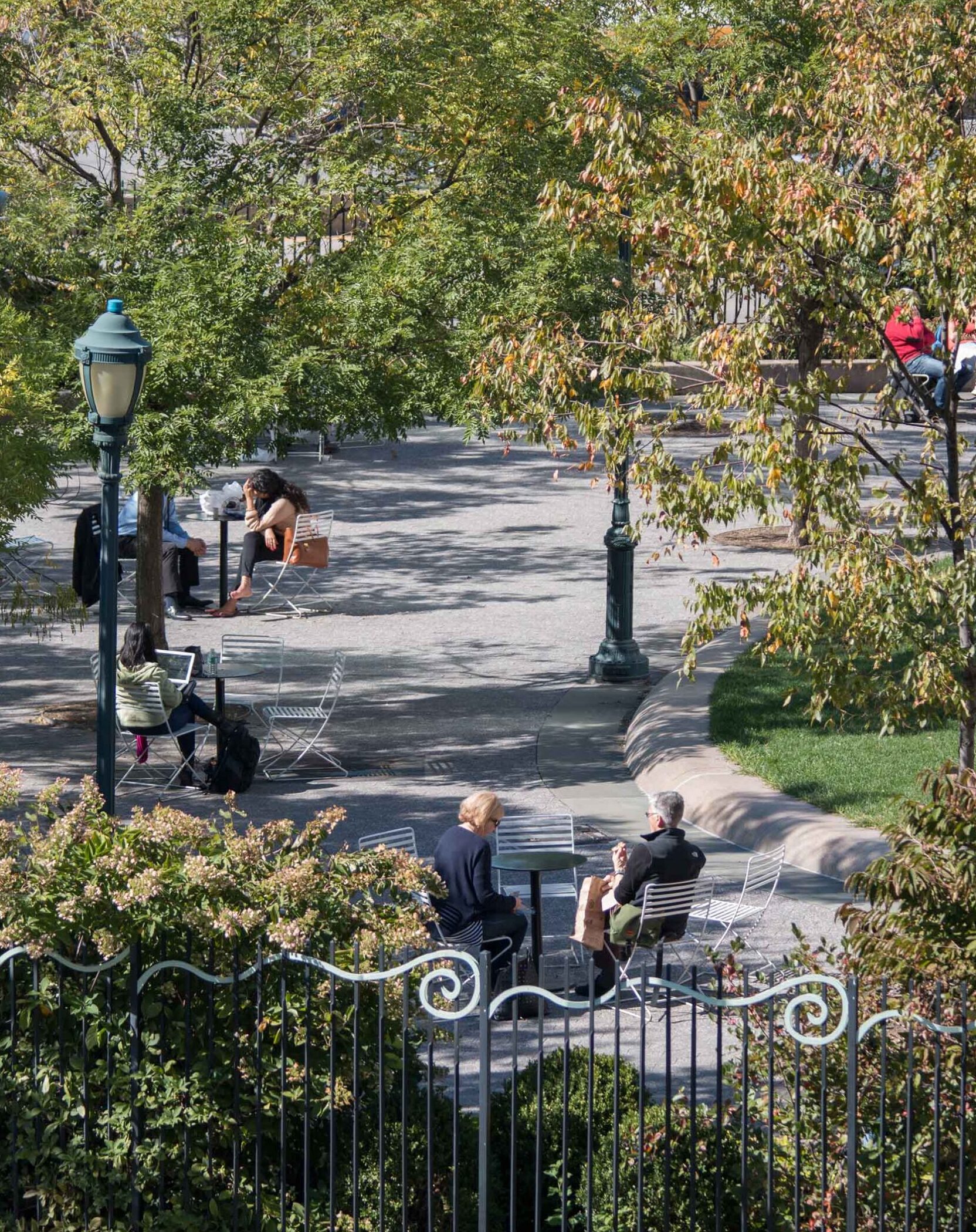 Tables and chairs around the green circle at 14th Street park