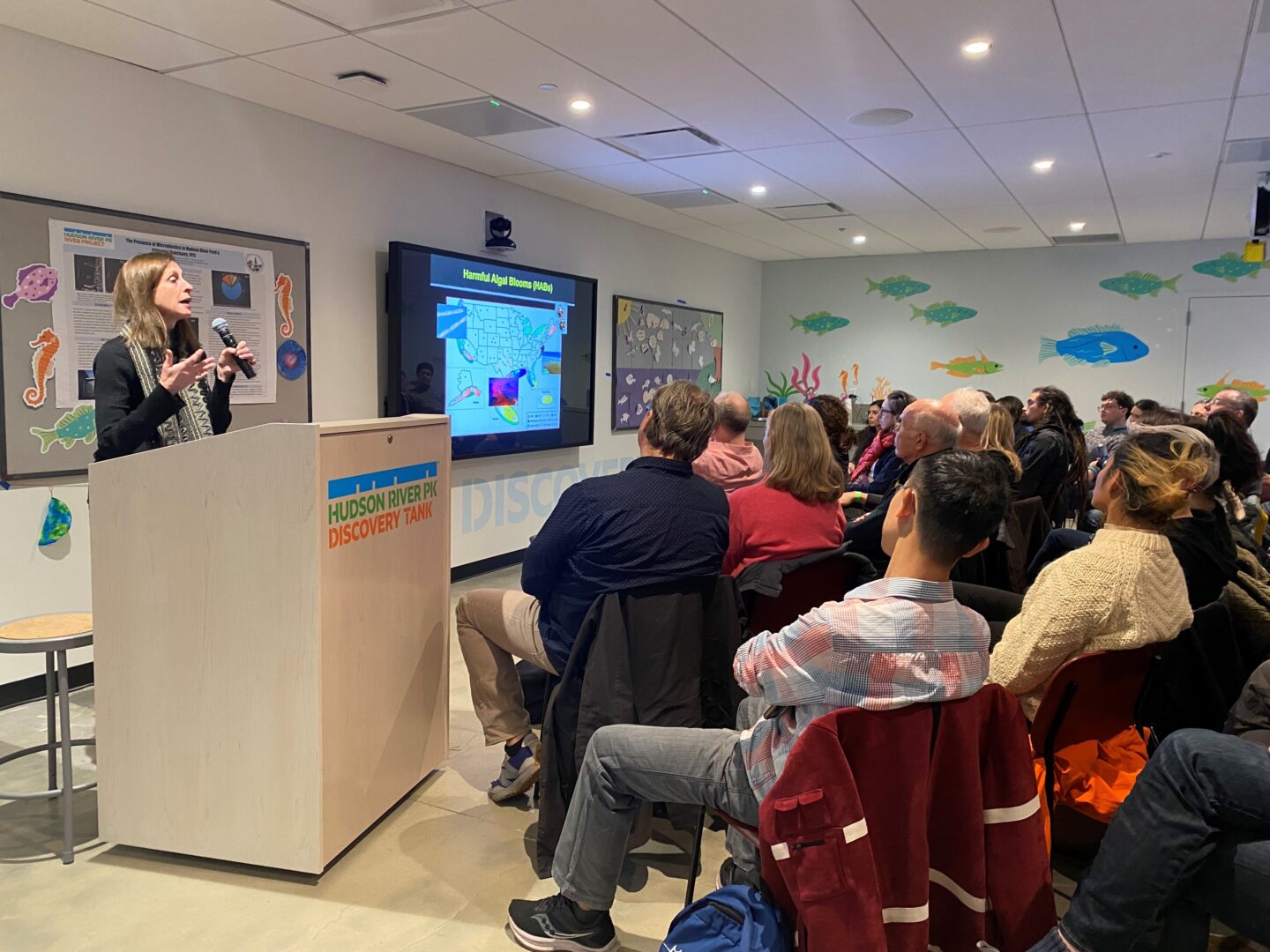 A scientist giving a presentation to an audience at the Pier 57 Discovery Tank