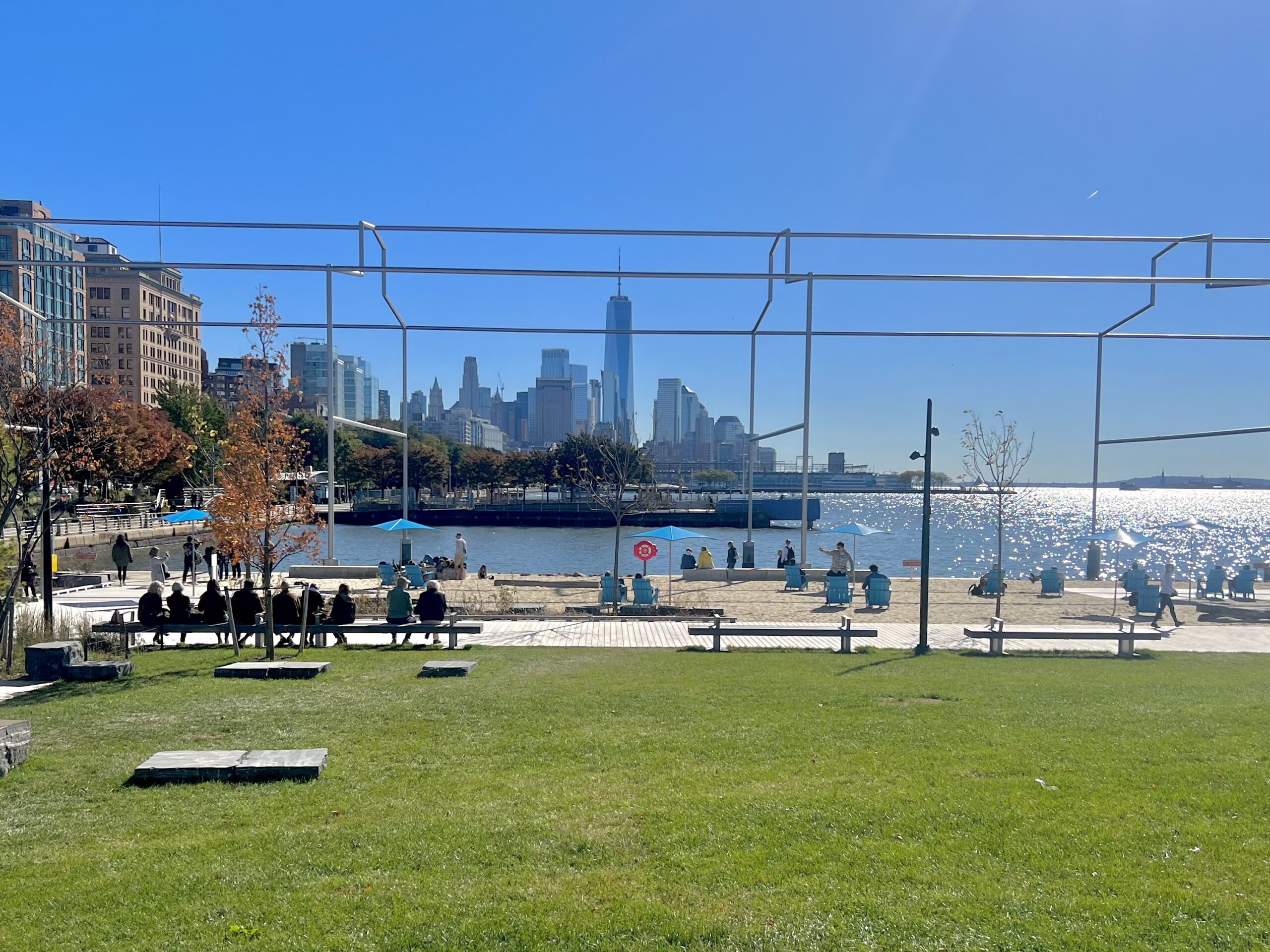 The lawn and beach at Gansevoort Peninsula, with Day's End and the Lower Manhattan skyline in the distance.