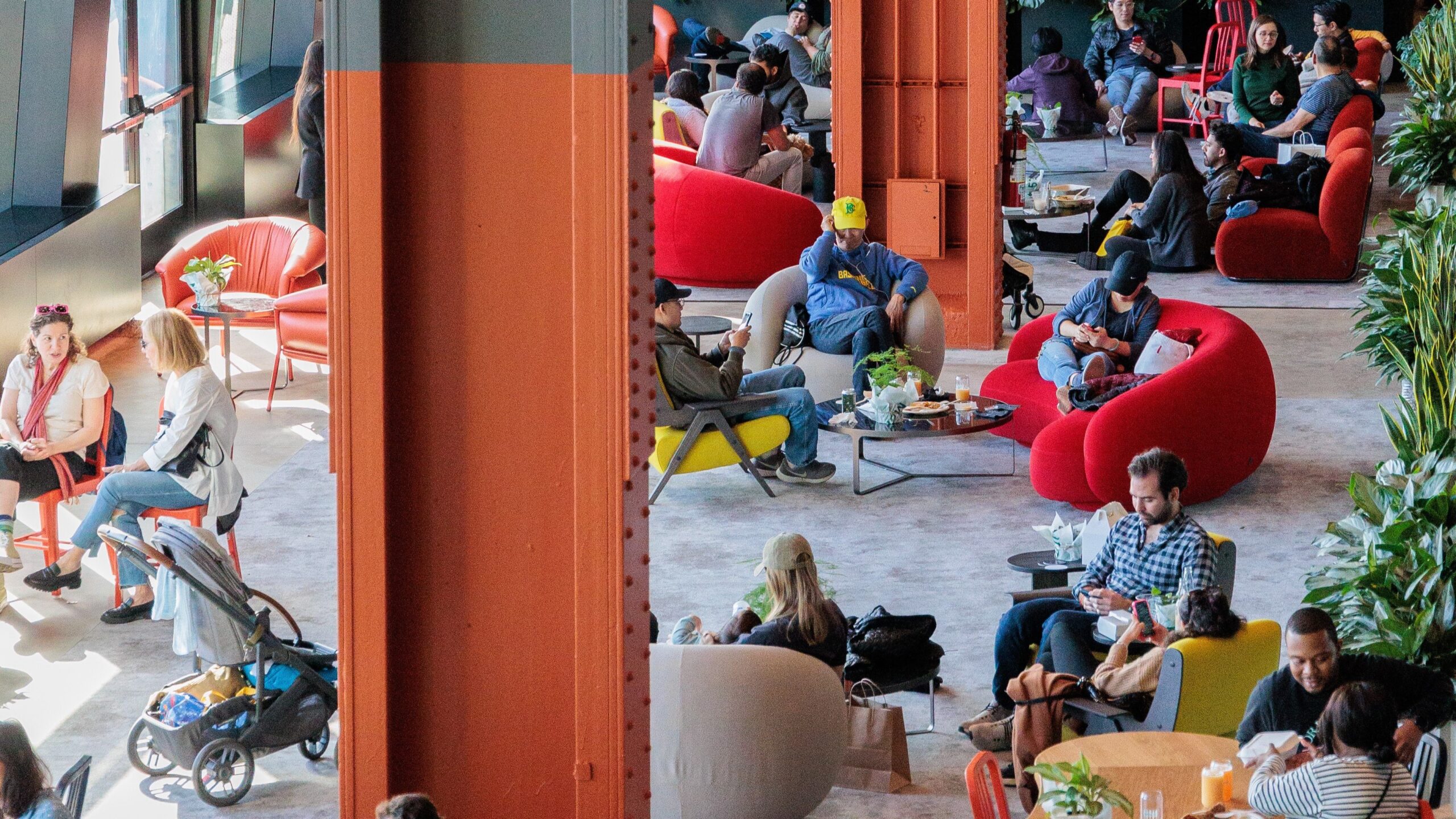 Groups of people sitting in chairs and at tables throughout the Pier 57 Living Room