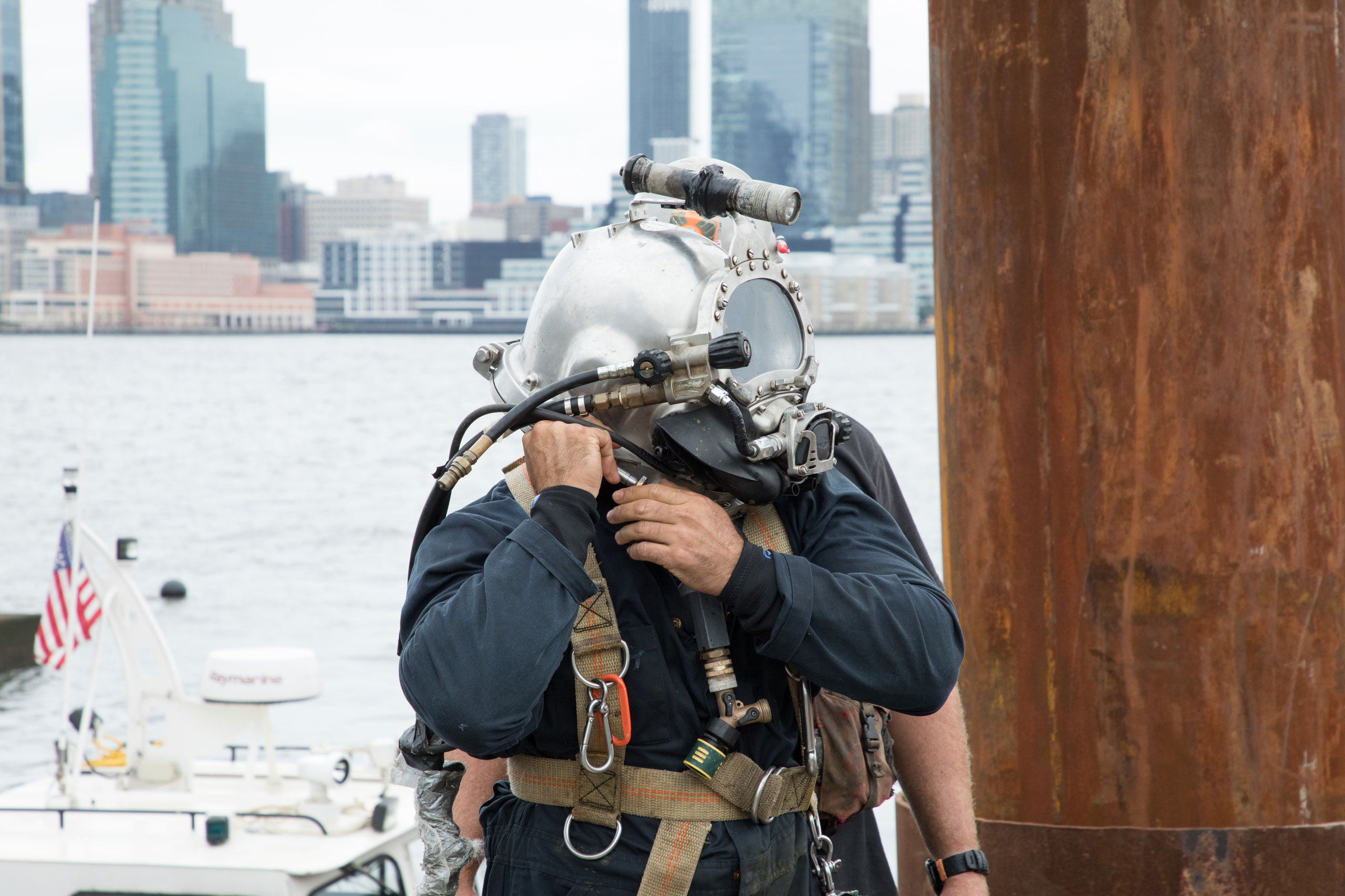 Man secures scuba gear and helmet in preparation for the oyster gabion installation as part of the HRPK Tribeca Habitat Enhancement Project